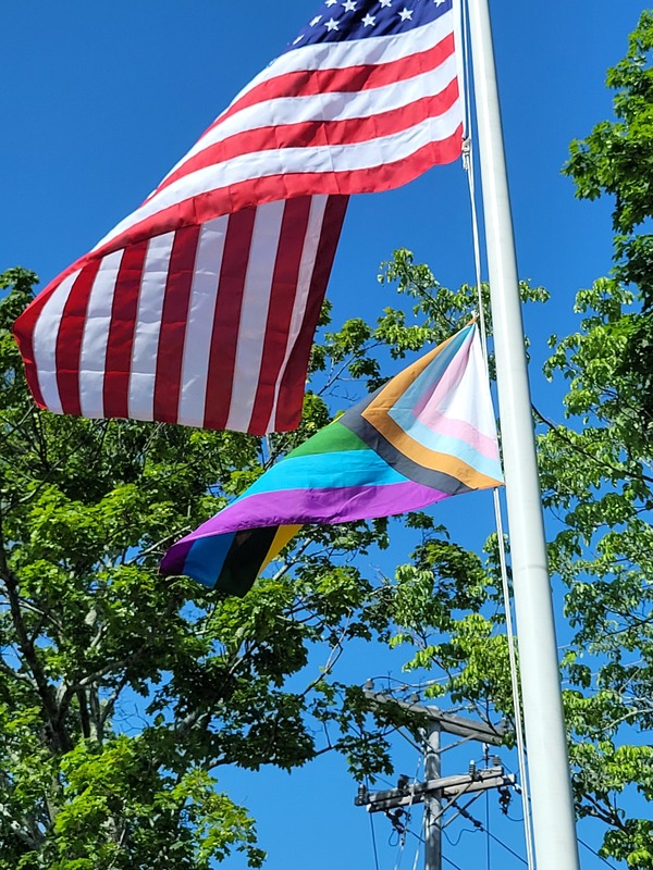 The American Flag and the PRIDE flag flutter in the breeze.