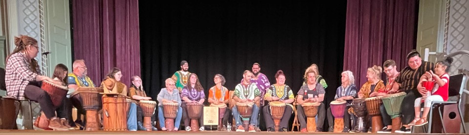 Members BSU of Khakatay Drumming Ensemble, plus two children, performing onstage.