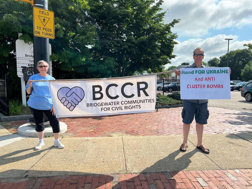 BCCR members hold a BCCR banner and a sign saying, 